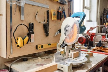 Yatay olarak, marangozluk atölyesinde testere ve çeşitli alet ve teçhizat kullananlar yok.