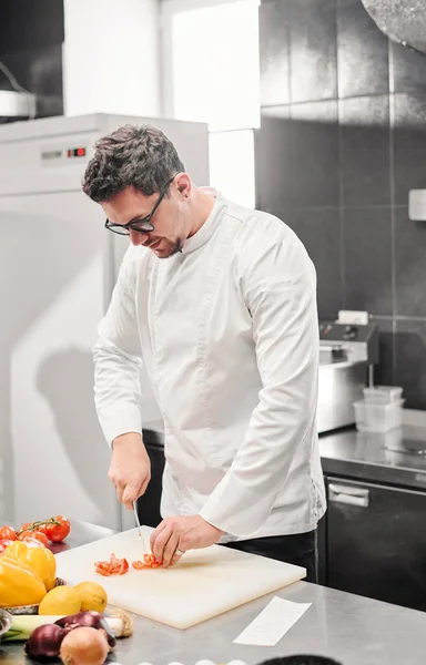 Joven Chef Anteojos Tomate Corte Uniforme Blanco Tabla Cortar Mesa — Foto de Stock