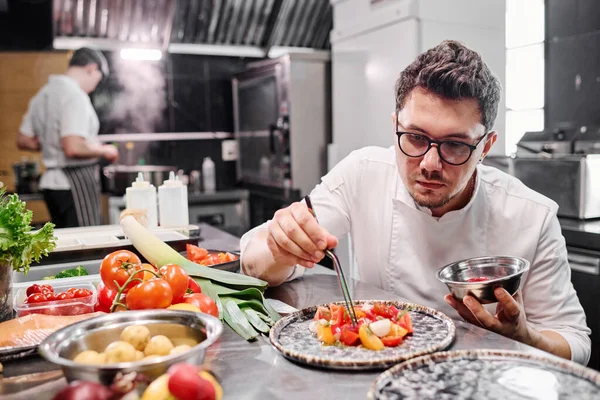 Joven Chef Anteojos Decorando Plato Con Verduras Plato Mesa Cocina — Foto de Stock