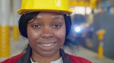 Afro-Amerikalı kadın fabrika işçisinin portresi. Kameraya gülümseyerek poz veriyor.