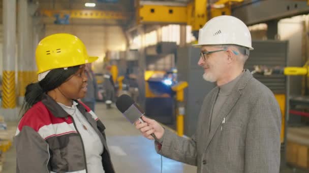 Афроамериканка Инженер Каске Рабочей Одежде Говорит Микрофоне Камеру Давая Интервью — стоковое видео