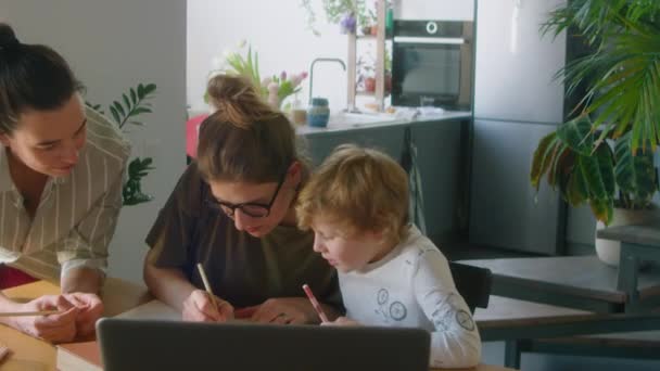 Νέοι Λεσβιακοί Γονείς Βοηθούν Τον Μικρό Τους Γιο Την Εργασία — Αρχείο Βίντεο