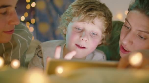 Söt Liten Pojke Läser Godnattsaga Digital Tablett Medan Ligger Med — Stockvideo
