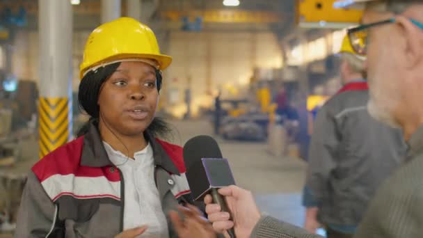非洲裔美国女工程师头戴硬礼帽 身穿制服 头戴话筒 在接受电视记者采访时拍了照 — 图库视频影像