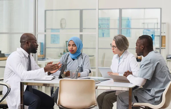 Grupo Médicos Sentados Mesa Planificando Trabajo Juntos Durante Reunión Consultorio —  Fotos de Stock