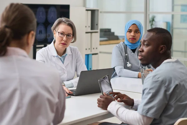 Grupo Médicos Escuchando Colega Mientras Usa Aparatos Durante Trabajo Equipo —  Fotos de Stock