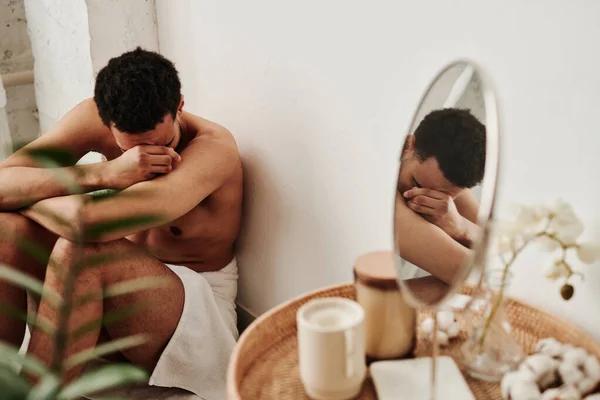 若い男は手で顔を覆い バスルームで床で泣いて 彼は感情的なストレスを持っています — ストック写真