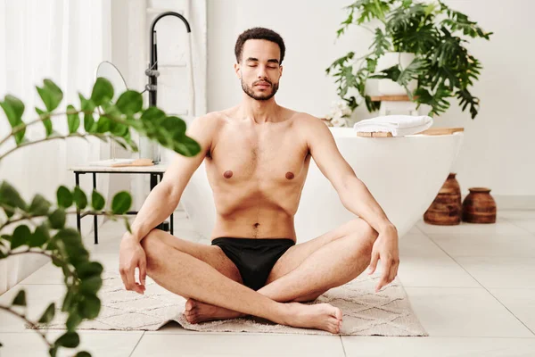 Joven Hombre Sin Camisa Sentado Alfombra Posición Loto Meditando Con — Foto de Stock