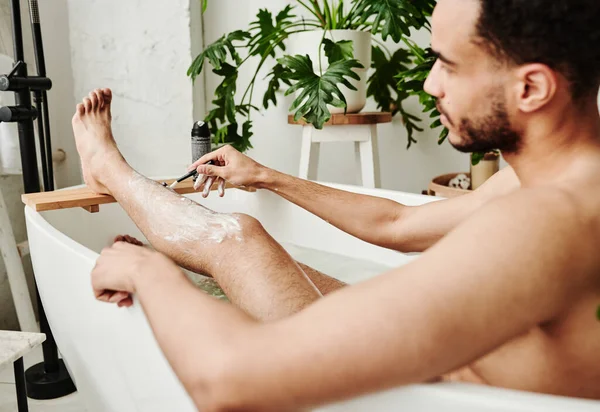 Jovem Metrosexual Cara Sentado Banho Banheiro Raspando Pernas Com Navalha — Fotografia de Stock