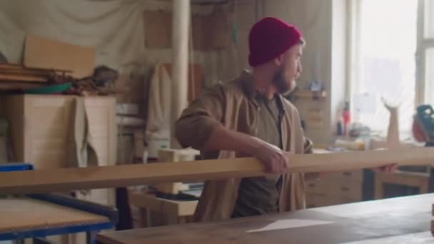 Jonge Bebaarde Houtbewerker Rode Muts Zet Plank Werkbank Timmerwerk Werkplaats — Stockvideo