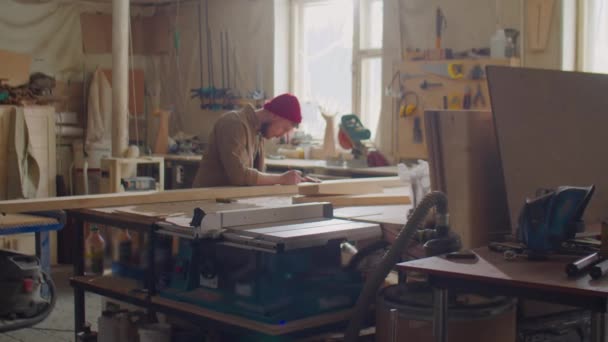 Szerokie Ujęcie Profesjonalnego Stolarza Wykonującego Pomiary Drewnianej Deski Linijką Ołówkiem — Wideo stockowe
