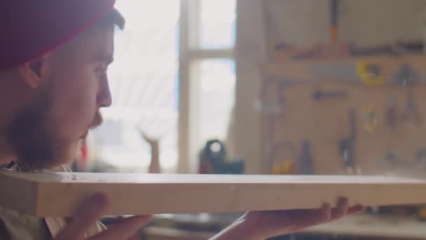 Houtbewerker Blaast Stof Van Houten Plank Onderzoekt Het Tijdens Het — Stockvideo