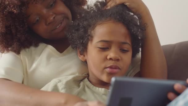 Radosna Afroamerykanka Przytulająca Się Synka Kanapie Uśmiechająca Się Rozmawiająca Nim — Wideo stockowe