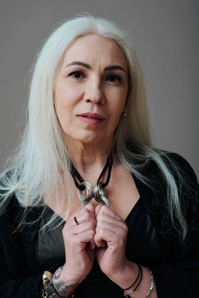 stock image Vertical medium close-up studio portrait of stylish mature Caucasian woman wearing modern goth clothes looking at camera