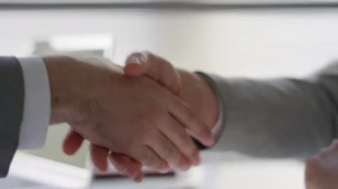 Ofis toplantısı sırasında tanınmayan iki iş ortağının el sıkışmasını yakından çek.
