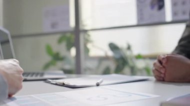 Ofisteki iş görüşmesinde resmi takım elbiseli iki erkek meslektaşın el sıkışmasını yakından izleyin.