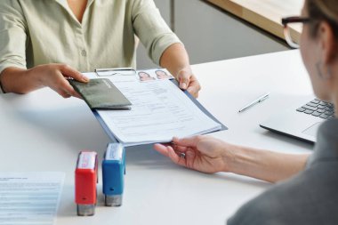 Tanımlanamayan bir kadının seyahat vizesi başvurusu, pasaport başvurusu, konsolosluk memuruna fotoğrafları olan başvuru formu.