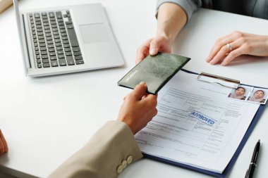 Müslüman kadının yatay olarak yüksek açıyla vizesini başvuru onayı aldıktan sonra memurlara vermesi.
