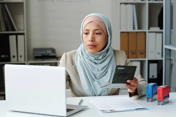 히잡을 책상에 이슬람 대사관 사무실에서 노트북을 사용하는 신청자 서류와 일하고 — 스톡 사진