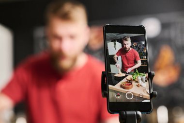 Modern Kafkas yemek blogcusunun akıllı telefon kamerasında makarna pişirme sürecinin seçmeli odak noktası.