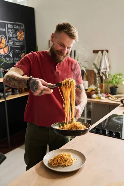 Fröhlicher Kaukasischer Koch Steht Der Loftküche Und Serviert Heiße Spaghetti — Stockfoto
