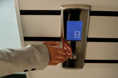 İş kadını asansörün düğmesine basıyor ve ofis koridorunda onu bekliyor.