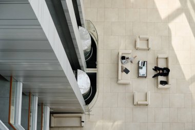 Asansörlü modern ofis salonu manzarası ve koltukta oturan iş adamları.