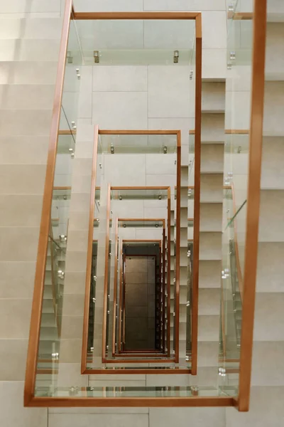 Vertical image of modern staircase with glass railing in high office building