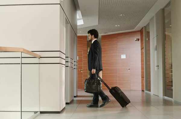 Takım Elbiseli Genç Işadamı Bavul Çantayla Ofis Koridorunda Asansörü Bekliyor — Stok fotoğraf