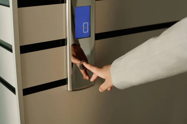 stock image Close-up of businesswoman pushing button of elevator standing in the corridor of office building