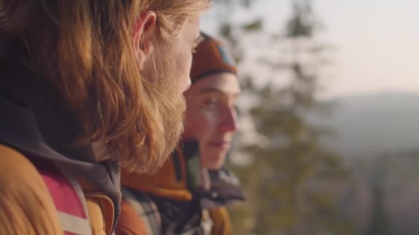 山の上に立つ観光客のカップルを撮影し 冬の森の美しい景色を議論ラックフォーカス — ストック動画