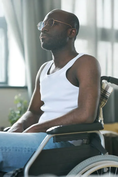 Afroamerykanin Okularach Niepełnosprawnością Siedzący Wózku Inwalidzkim Odwracający Wzrok Zamyślonym Wyrazem — Zdjęcie stockowe