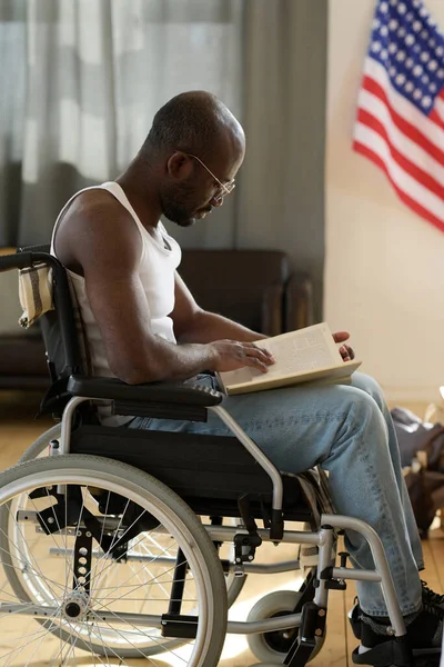 Африканський Чоловік Сидить Інвалідному Візку Зосереджується Читанні Книжки Під Час — стокове фото