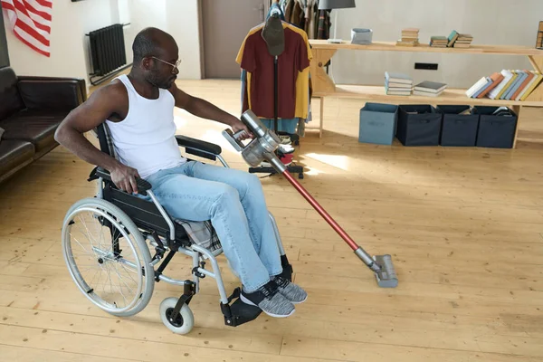 Африканский Инвалид Сидящий Инвалидной Коляске Моющий Пол Комнате Помощью Пылесоса — стоковое фото
