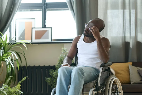 アフリカ系アメリカ人の男性が一人で車椅子に座って何かを考えて — ストック写真