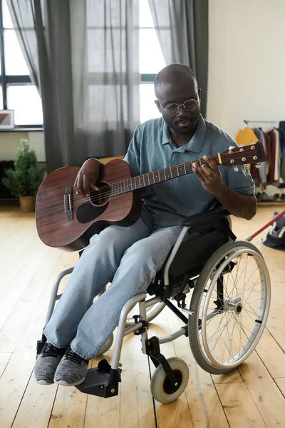 Afroamerykanin Niepełnosprawnością Siedzi Wózku Inwalidzkim Uczy Się Grać Gitarze Domu — Zdjęcie stockowe