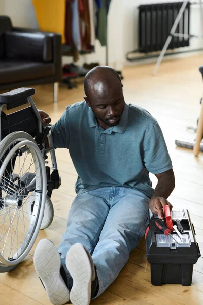 Африканский Молодой Человек Инвалидностью Сидит Полу Берет Инструменты Коробки Починить — стоковое фото