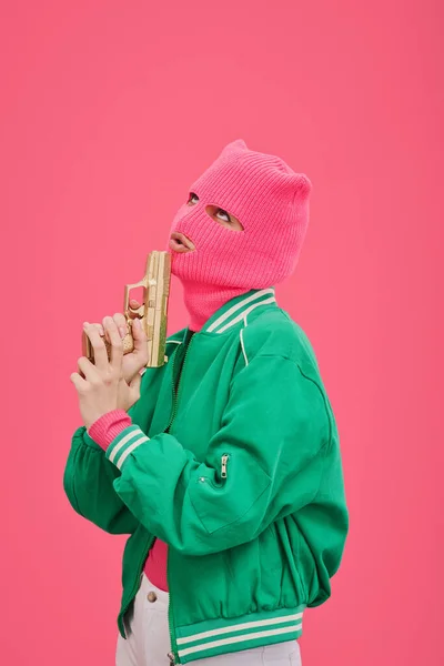 Νεαρή Γυναίκα Ροζ Κουκούλα Και Πράσινο Μπουφάν Ποζάροντας Όπλο Μπροστά — Φωτογραφία Αρχείου