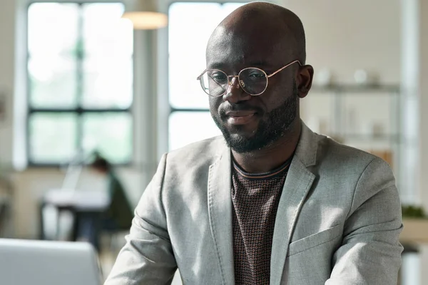 眼鏡のアフリカの若いビジネスマンは ラップトップ上の彼のオンライン仕事に集中 — ストック写真