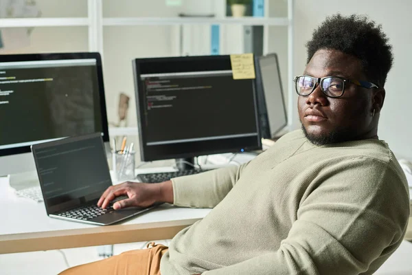 Ciddi Bir Afrikalı Programcı Ekranda Betikle Bilgisayar Ekranının Yanında Otururken — Stok fotoğraf