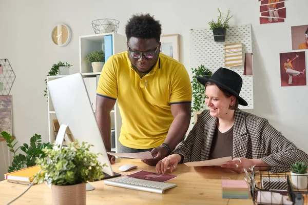 stock image Photo editor discussing professional photos with designer at table with computer at office