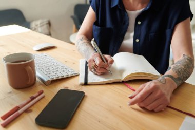 Kadının yapılacaklar listesini yapıp not defterine yazarken, çalışma odasında oturduğu sırada.