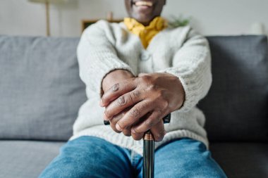 Afrikalı son sınıf öğrencisinin kanepede sırıtarak dinlendiği yakın plan.