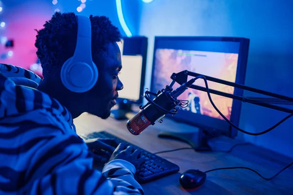 Adolescente Africano Auriculares Hablando Micrófono Mientras Juega Videojuegos Computadora Durante —  Fotos de Stock