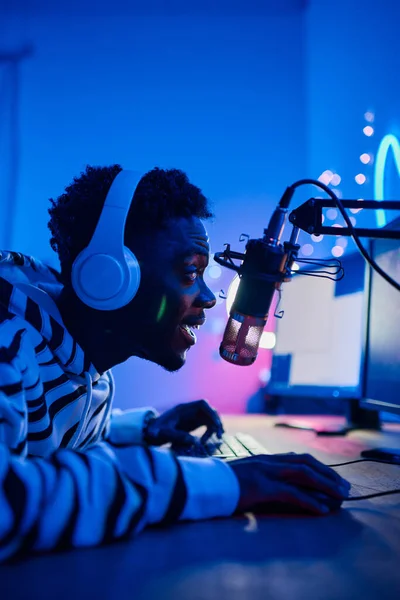 Africano Emocionado Gamer Chico Auriculares Hablando Micrófono Audiencia Mientras Juega —  Fotos de Stock