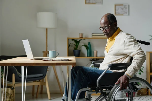 Африканский Взрослый Мужчина Сидит Инвалидной Коляске Столом Ноутбуком Проводит Время — стоковое фото
