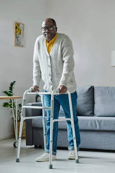 Portret Dojrzałego Afrykańskiego Mężczyzny Próbującego Chodzić Walkerem Podczas Rehabilitacji Domu — Zdjęcie stockowe