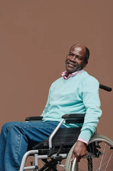 ベージュを背景に車椅子に座っているアフリカの高齢者の肖像 — ストック写真
