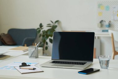 Masada dizüstü bilgisayarı ve akıllı telefonu olan iş adamının yatay görüntüsü