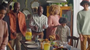 Büyük Afro-Amerikan ailesi yemek masasında birlikte oturuyorlar. Babaları onları davet ediyor. Tatil yemeği için evde toplanıyorlar.